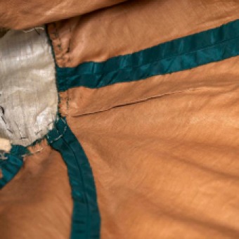 The brown cotton underlining of this bodice provides a beautiful contrast to the green silk taffeta of the outer fabric. The taffeta and cotton layers were cut and sewed as one piece. When the seams were opened, the edge of the taffeta was turned under and finished.