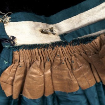 The extreme fullness of the skirt is brought into the waist with a series of cartridge pleats stitched to the waistband. While the earlier skirts would have been pleated all the way around the waist, by the 1860s, such pleating was only at the back. To add strength, the section that is pleated has been lined with polished cotton.