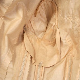 The dress includes shields in the armpits to protect the silk from staining and discoloration.