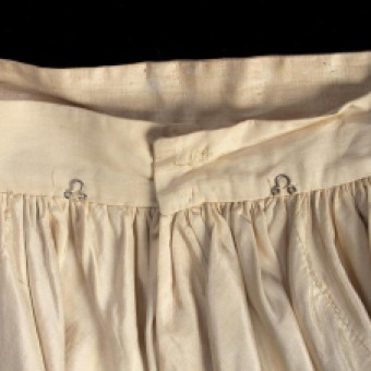 The waist of the skirt has two eyes at the center back, which align with corresponding hooks on the inside of the bodice. These points of attachment ensured that the dress remained straight and in place.
