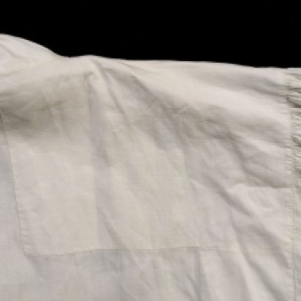 This photograph shows the interior of the shirt. The shoulder is reinforced with an appliqué added to the inside.