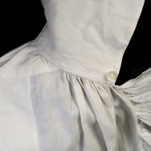 The shirt is reinforced in areas that would take the most wear. Across the shoulders and at the top of the side slit, additional pieces of linen have been appliqued to the reverse of the fabric.